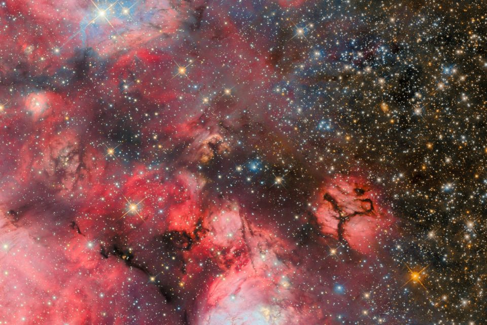 Stellar nursery emerges from the darkness with a red glow